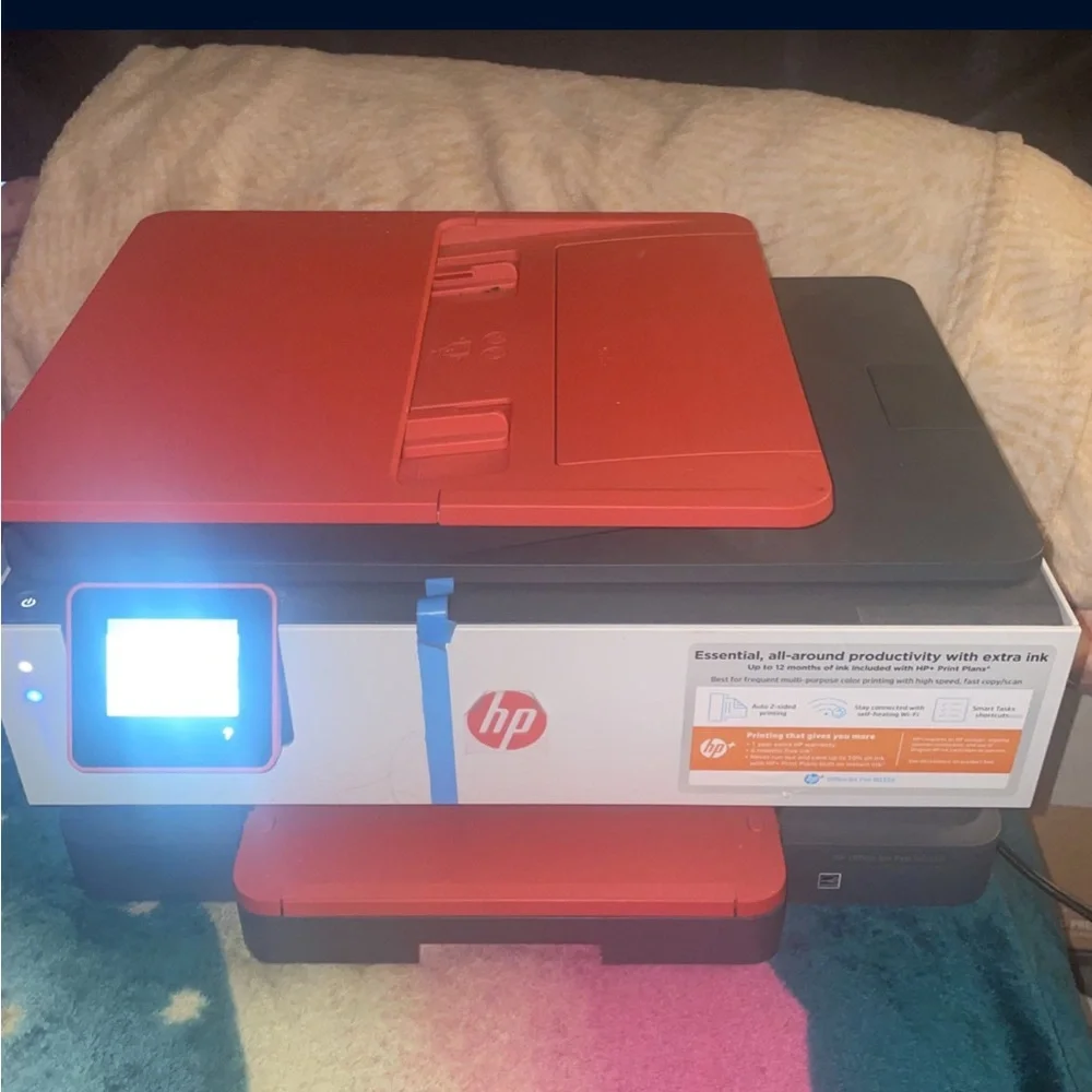 Red and white HP Printer . It’s brand new comes with paper and everything .